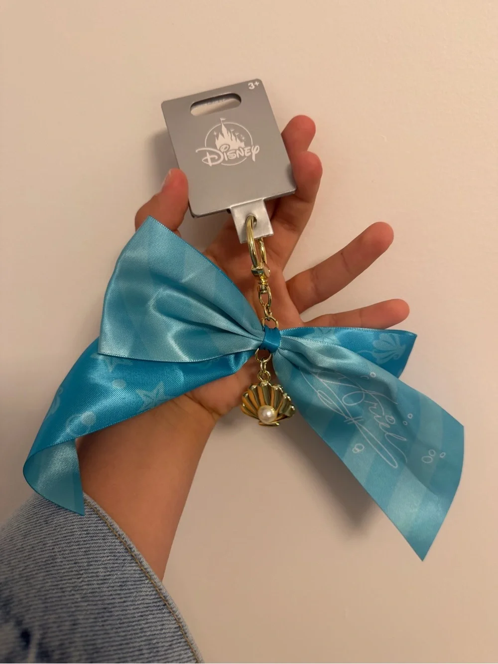 Disney Teal Ribbon Keychain with Gold Shell and Pearl Charm